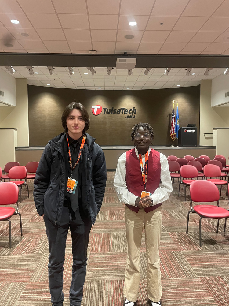 Two students pose  in front of a stage after a State Compeititon
