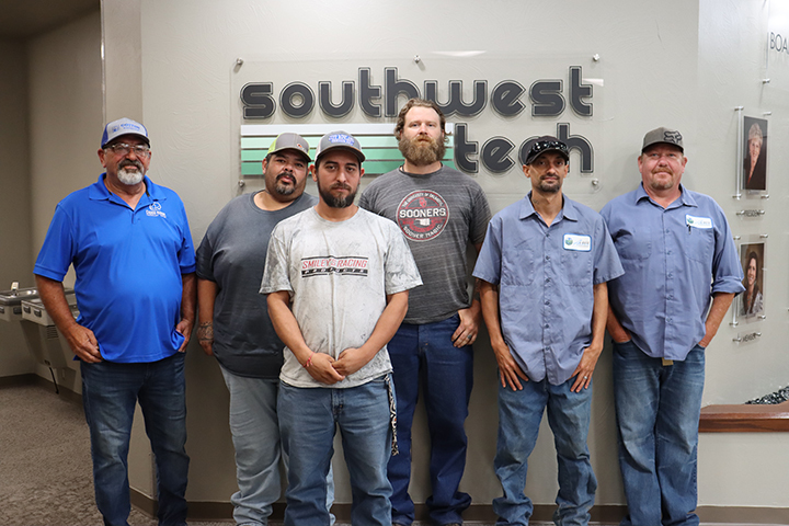 6 men standing in front of a SW Tech sign 